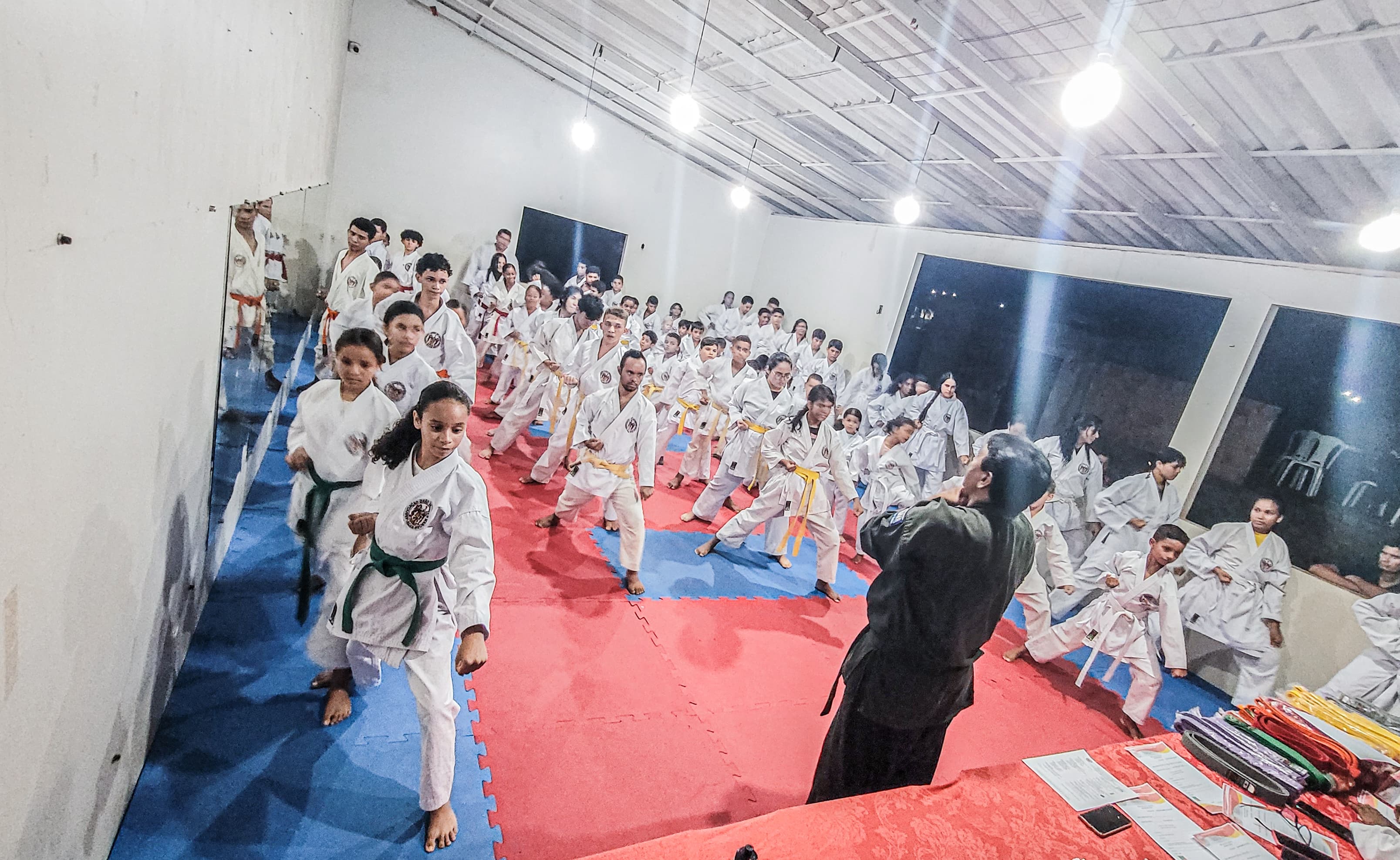Exame de alunos no karate na associação Girão, faixas coloridas.